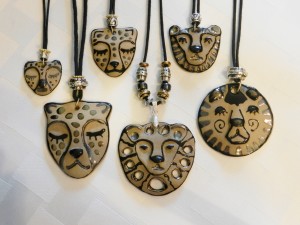 Handmade stoneware cheetah and lion pendants on adjustable cord necklaces
